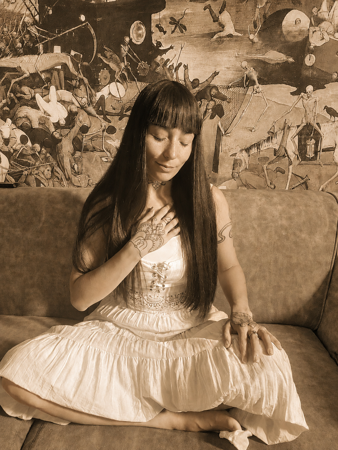 Karine Miras seated in front of a dreamlike mural